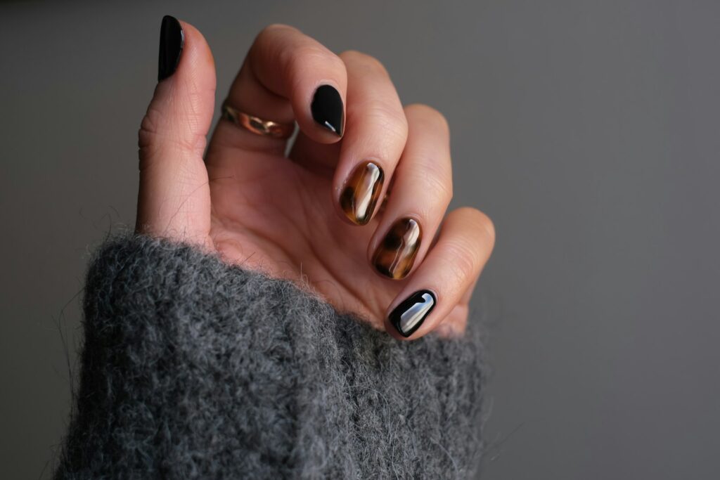 Hand met zwarte manicure en zilveren ring