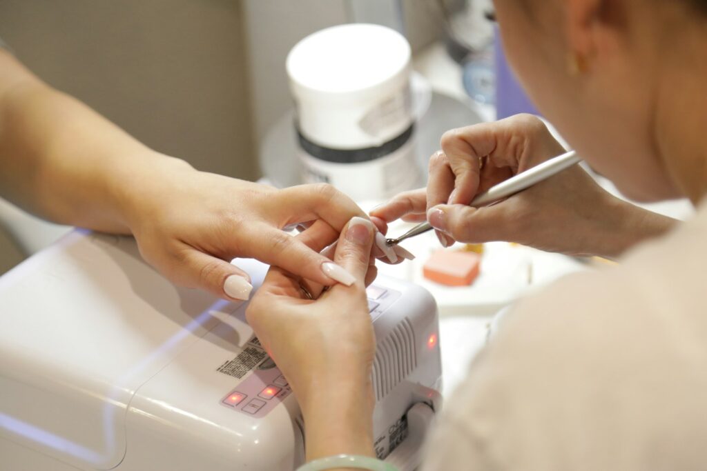 Nagelstyliste aan het werk tijdens een manicure